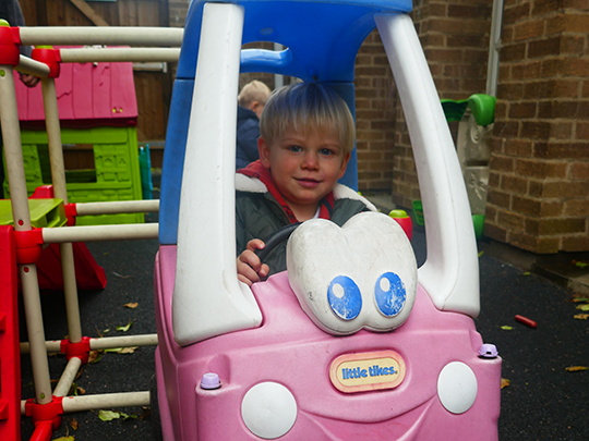 Child playing with car outdoors
